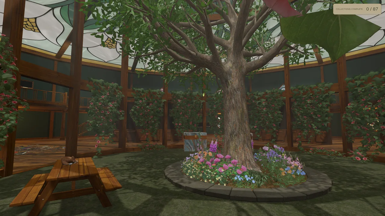 A tree and a bed of flowers beneath a stained-glass conservatory roof.